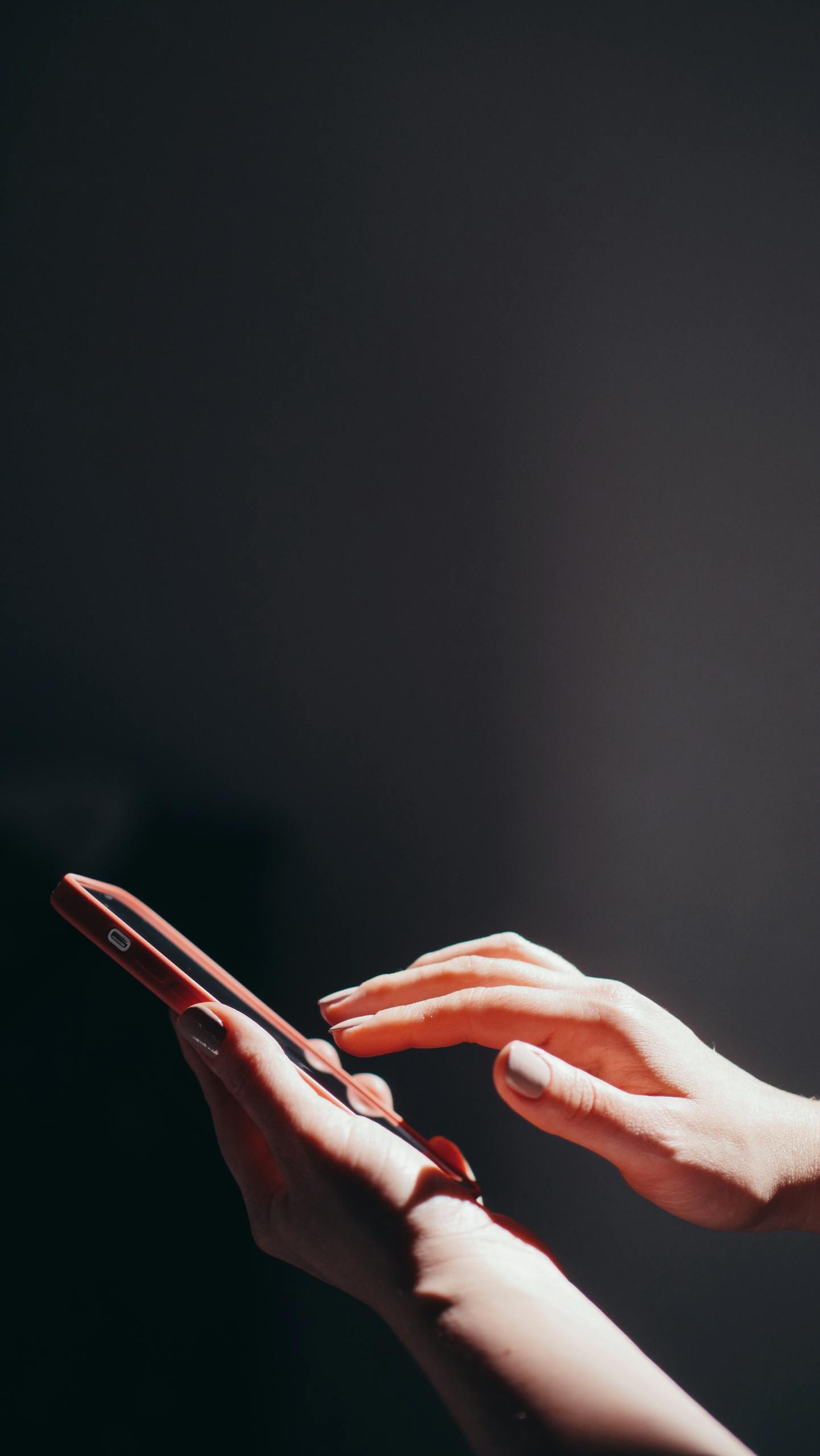 Hands interacting with a smartphone in a well-lit setting, emphasizing connection and technology.